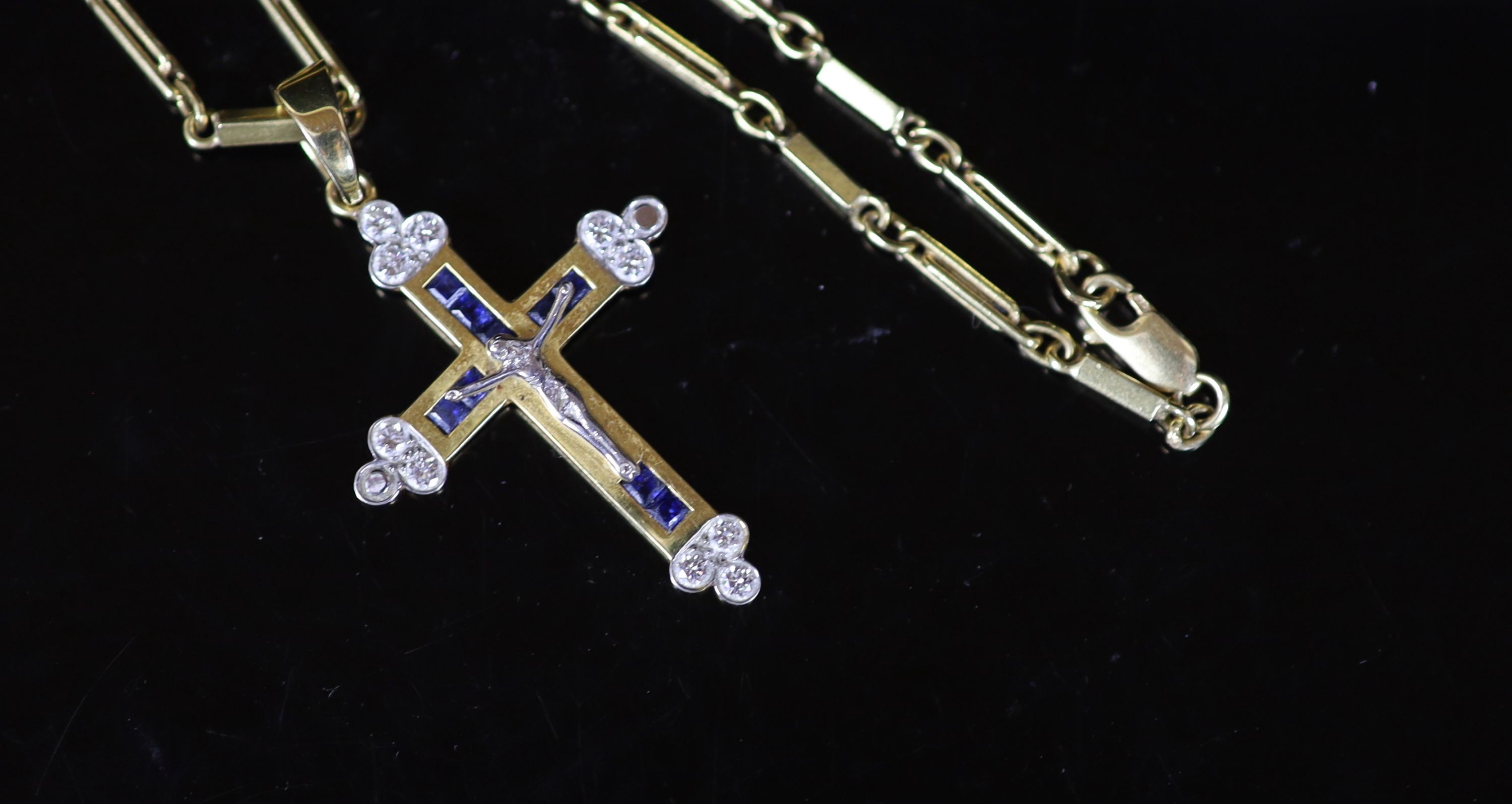 A modern 750 gold, sapphire and diamond set crucifix pendant, on a similar bar link chain